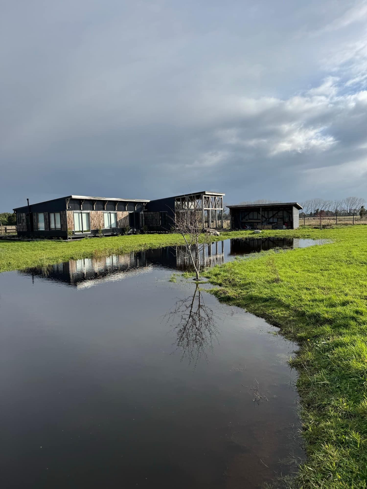 Fachada negra reflejada en el espejo de agua