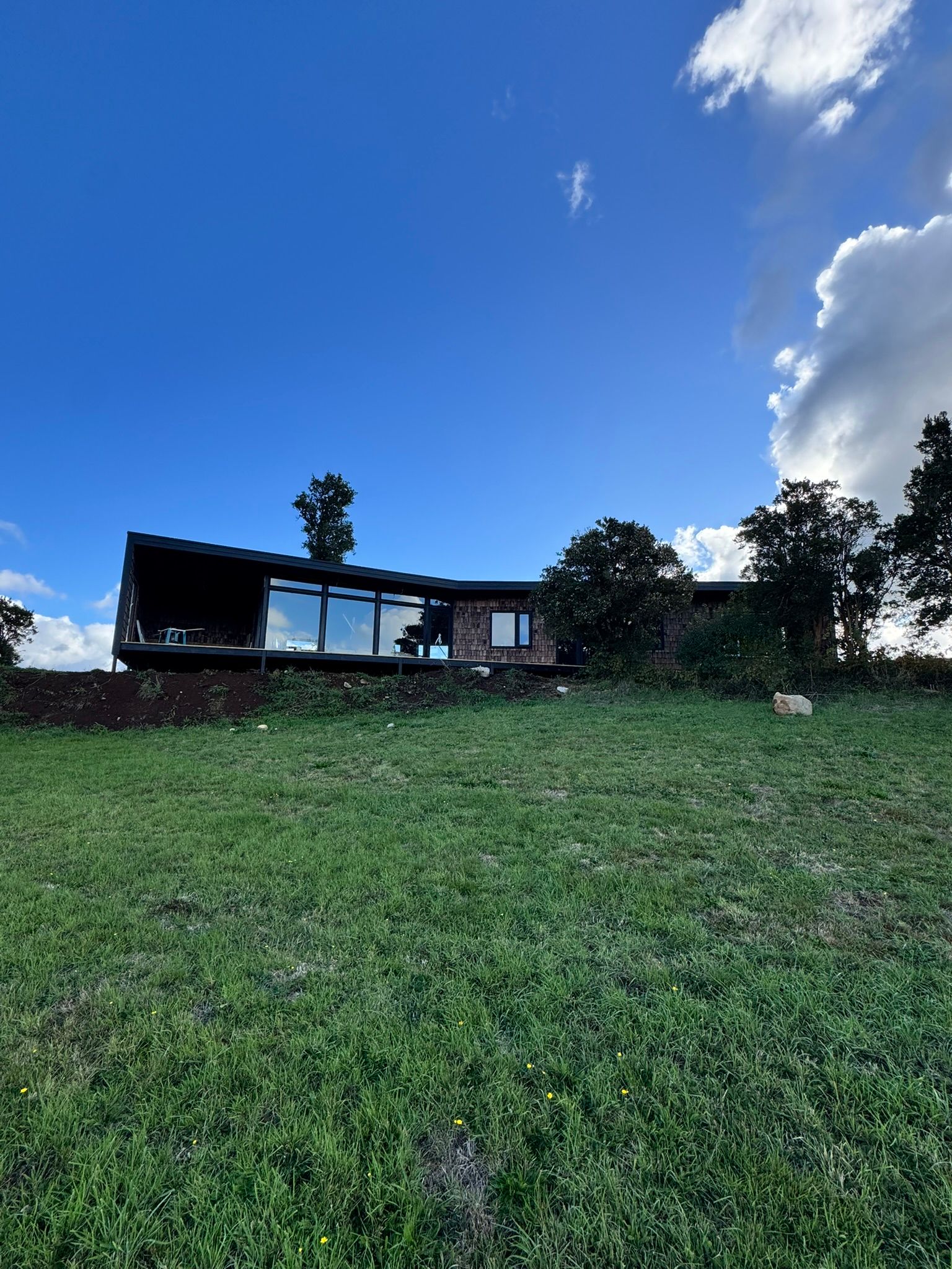 Casa de un piso sobre pradera abierta en el sur de Chile
