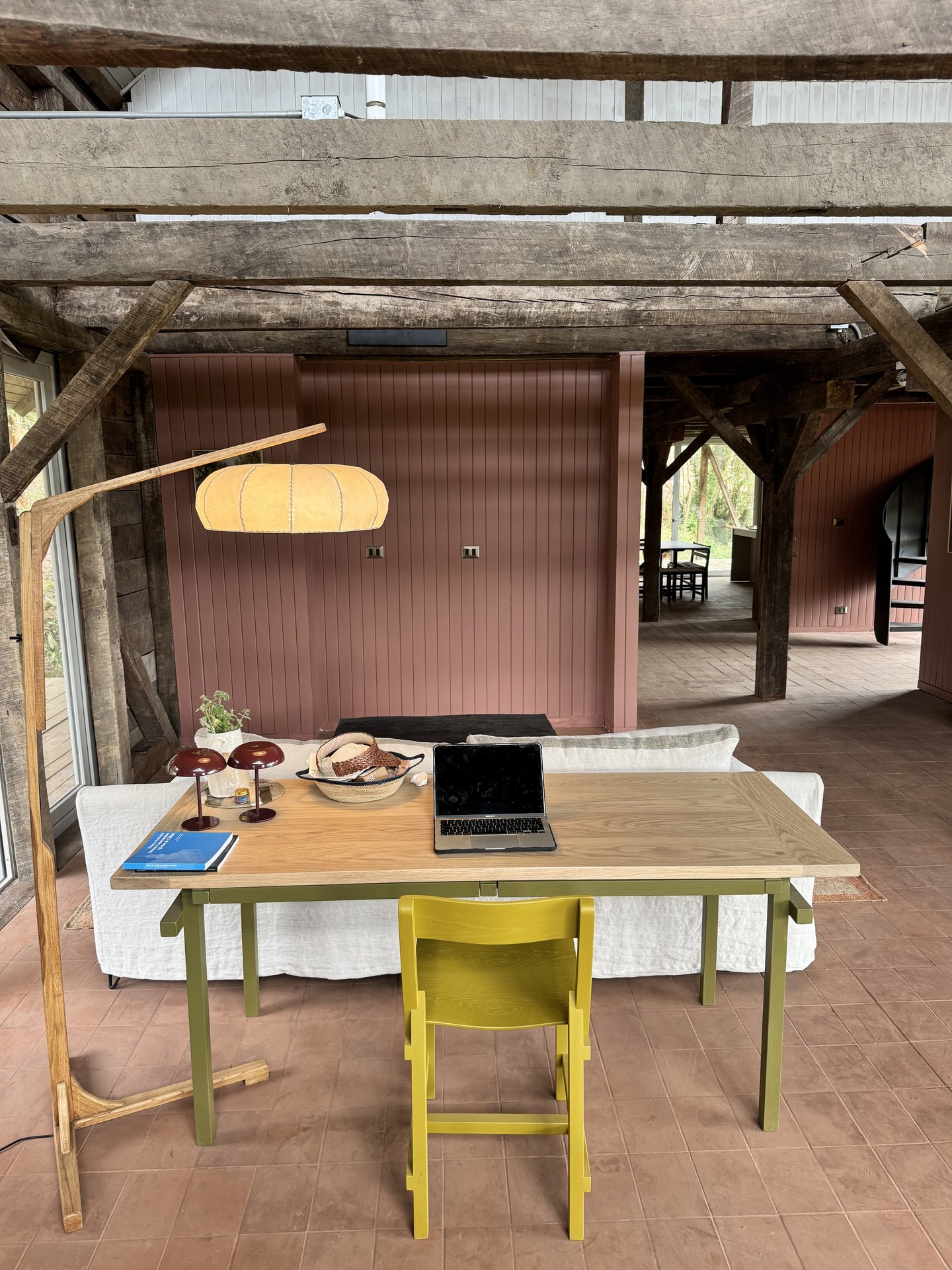 Zona de trabajo — mesa contemporánea, vigas centenarias y piso terracota